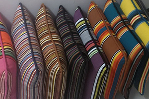A row of colorful pillows sitting on top of each other.