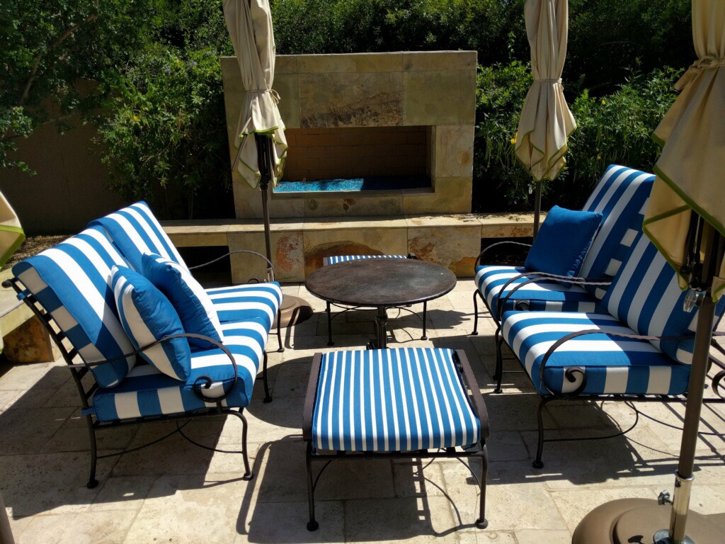 A patio with blue and white striped furniture.