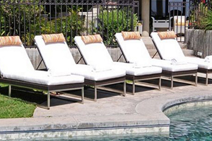 A row of lounge chairs next to the pool.