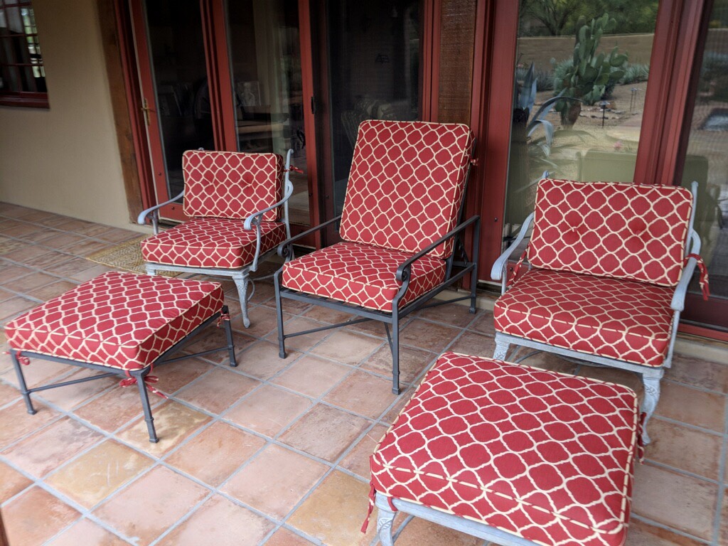A patio set with red and white cushions