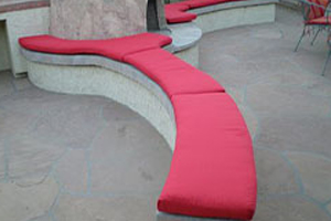 A red bench sitting on top of concrete.